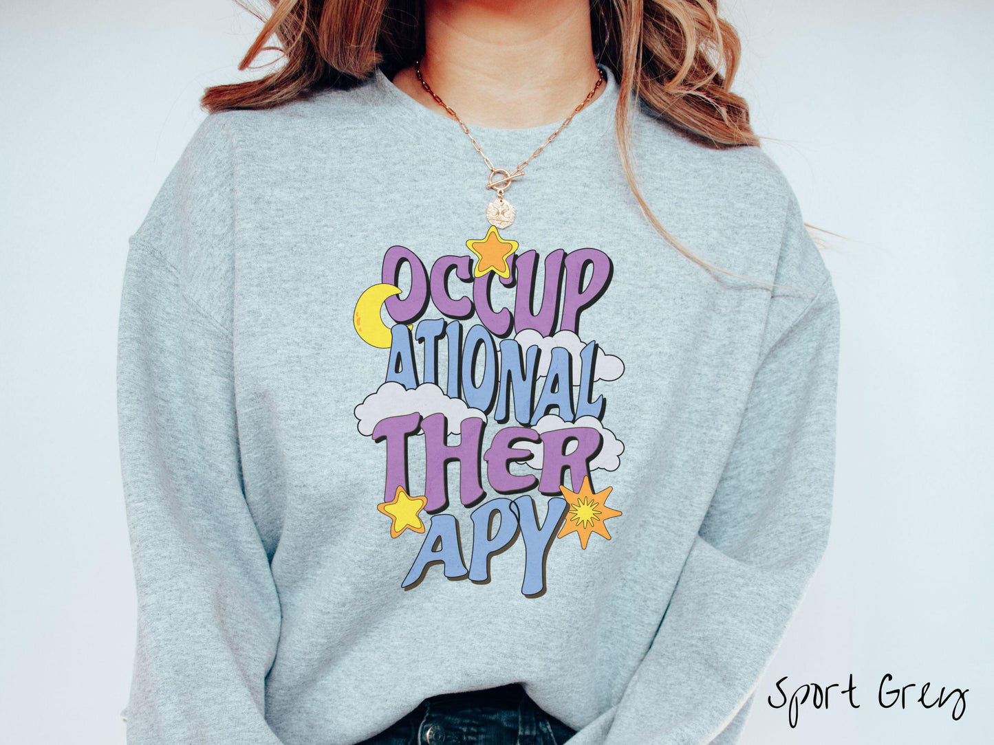 A vintage, sport grey colored Gildan sweatshirt with the text Occupational Therapy vertically with clouds, the yellow moon, and bright yellow and orange stars mixed in.