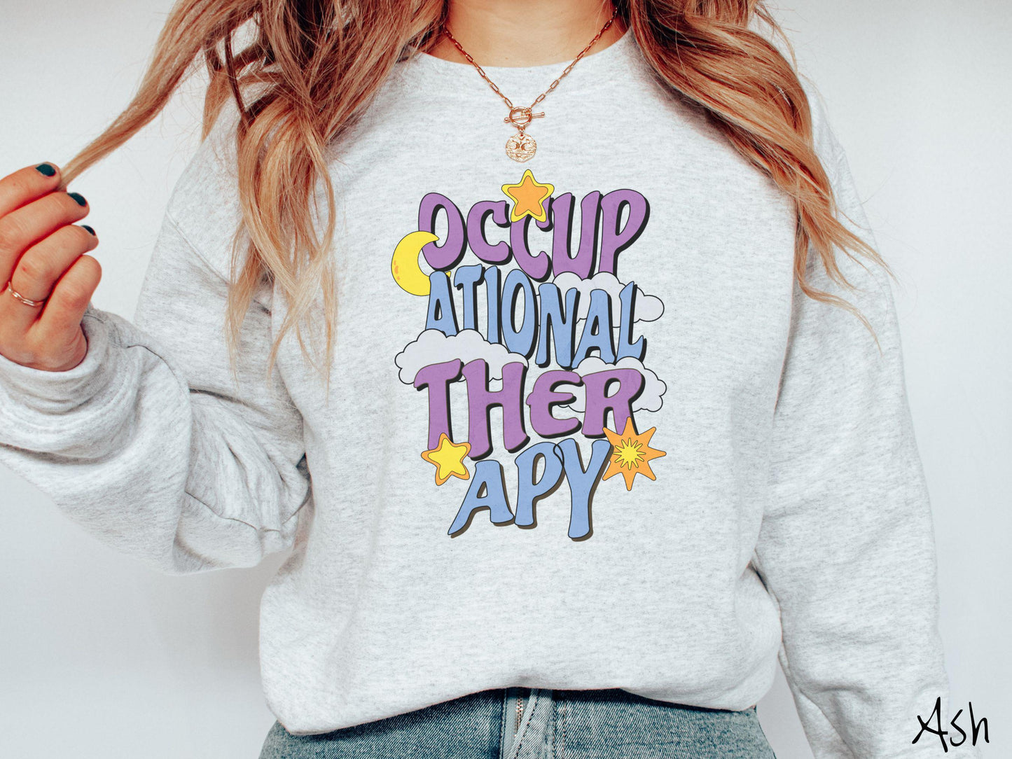 A vintage, ash colored Gildan sweatshirt with the text Occupational Therapy vertically with clouds, the yellow moon, and bright yellow and orange stars mixed in.
