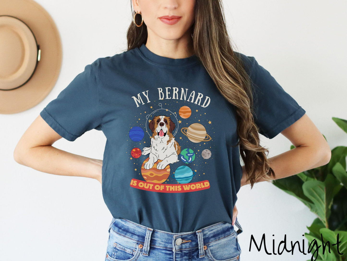 A vintage Comfort Colors t-shirt featuring the text 'My Bernard is Out of This World'. The design showcases an adorable St. Bernard sitting proudly atop Jupiter, surrounded by a vibrant solar system filled with colorful planets and twinkling stars.