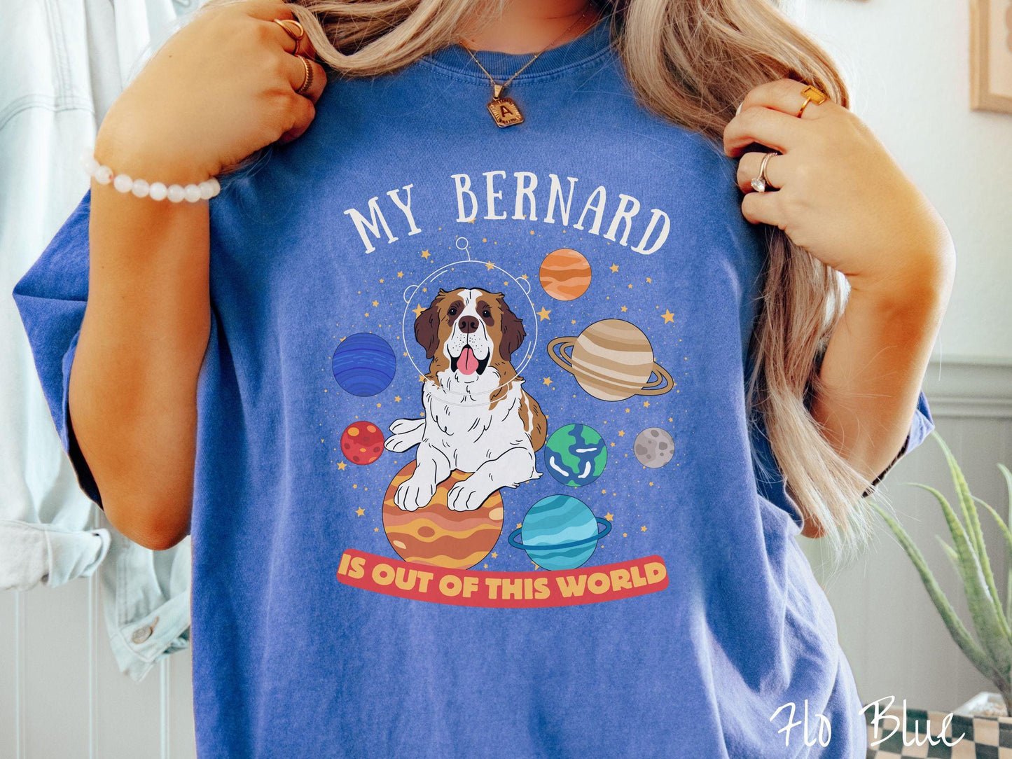A vintage Comfort Colors t-shirt featuring the text 'My Bernard is Out of This World'. The design showcases an adorable St. Bernard sitting proudly atop Jupiter, surrounded by a vibrant solar system filled with colorful planets and twinkling stars.