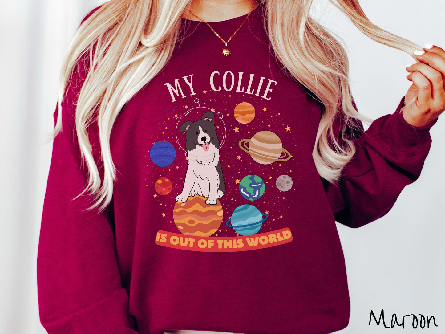 A vintage Gildan sweatshirt featuring the text My Collie is Out of This World. The design showcases an adorable Border Collie sitting proudly atop Jupiter, surrounded by a vibrant solar system filled with colorful planets and twinkling stars.