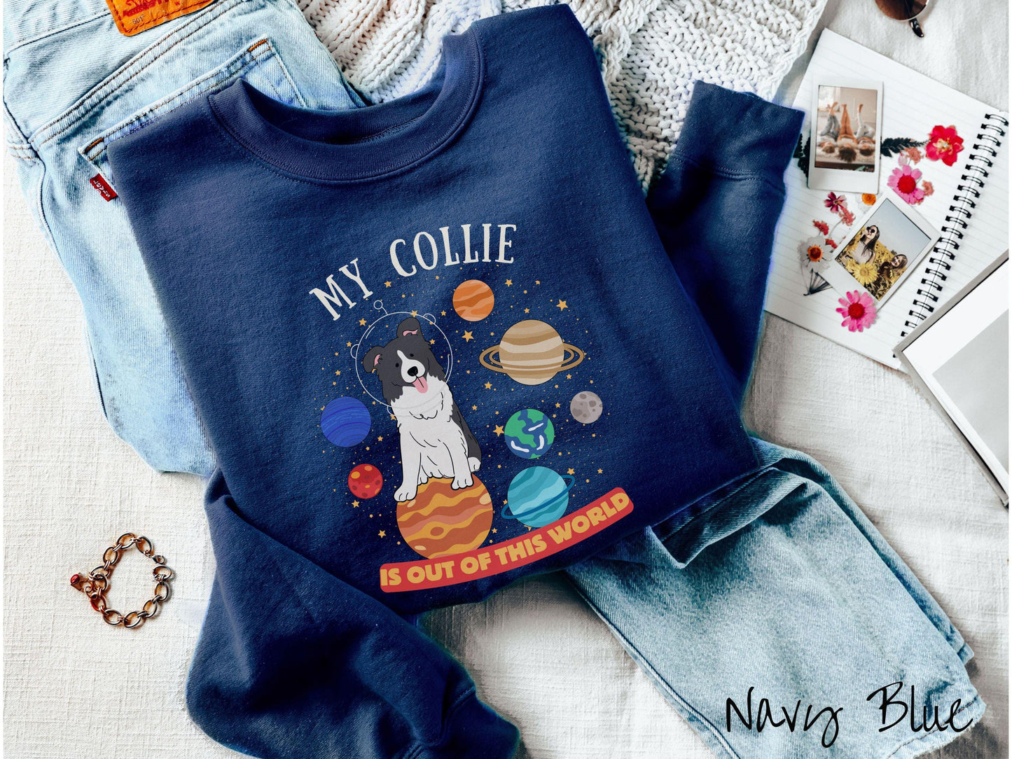 A vintage Gildan sweatshirt featuring the text My Collie is Out of This World. The design showcases an adorable Border Collie sitting proudly atop Jupiter, surrounded by a vibrant solar system filled with colorful planets and twinkling stars.
