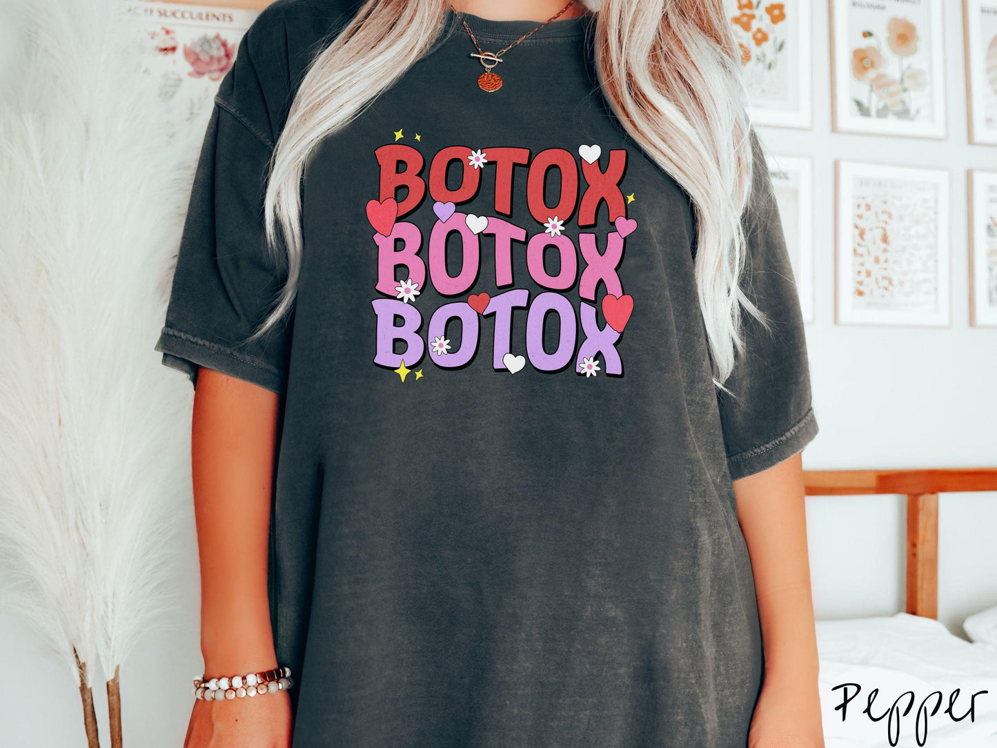 A vibrant Comfort Colors T-shirt with the text BOTOX written three times vertically, accompanied by tiny hearts, stars, and flowers. The perfect gift for friends who are into cosmetic botox nursing.