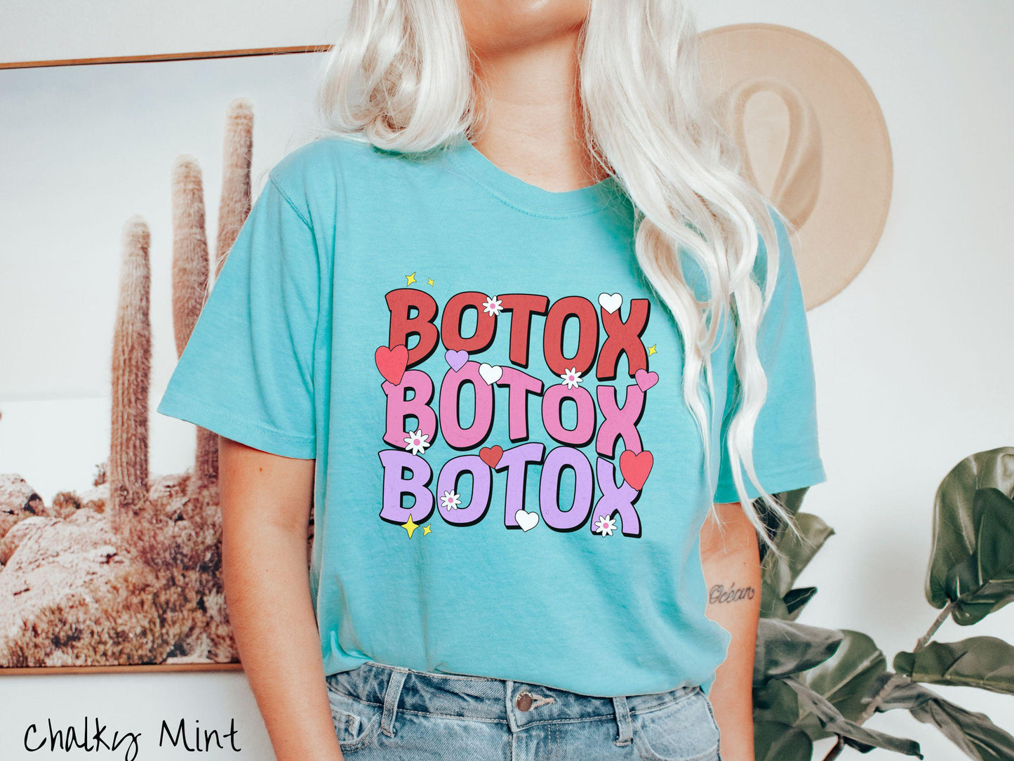A vibrant Comfort Colors T-shirt with the text BOTOX written three times vertically, accompanied by tiny hearts, stars, and flowers. The perfect gift for friends who are into cosmetic botox nursing.