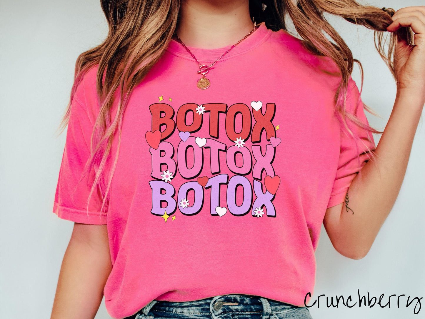 A vibrant Comfort Colors T-shirt with the text BOTOX written three times vertically, accompanied by tiny hearts, stars, and flowers. The perfect gift for friends who are into cosmetic botox nursing.