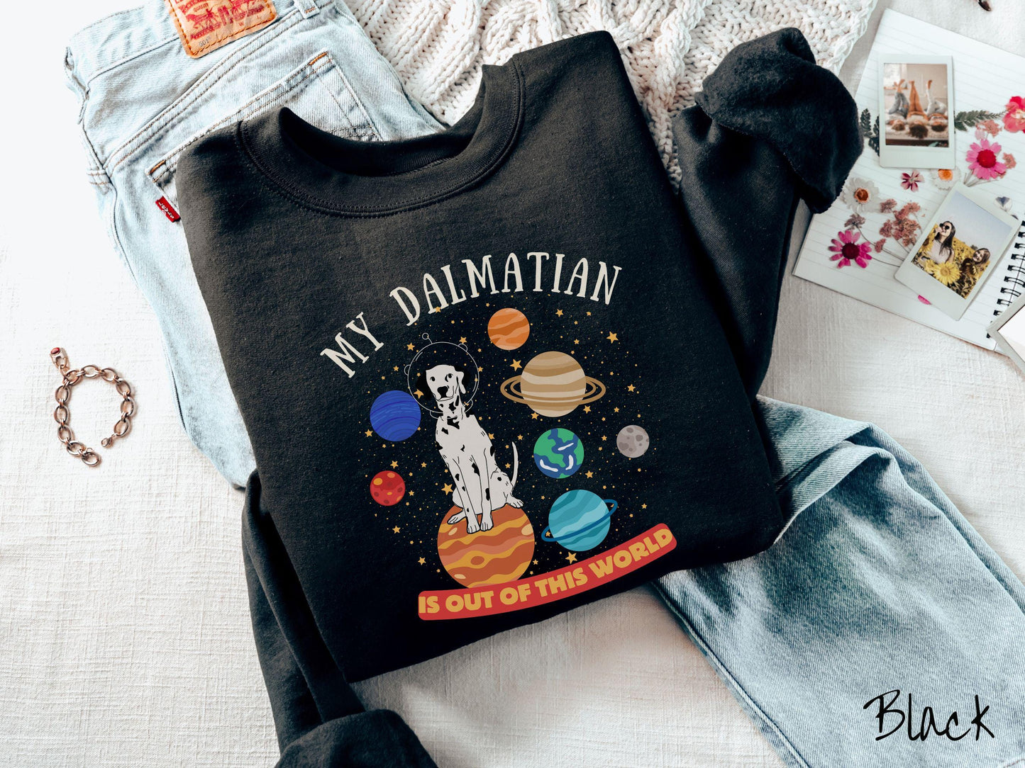 A vintage Gildan sweatshirt featuring the text My Dalmation is Out of This World. The design showcases a Dalmation sitting proudly atop Jupiter, surrounded by a vibrant solar system filled with colorful planets and twinkling stars.