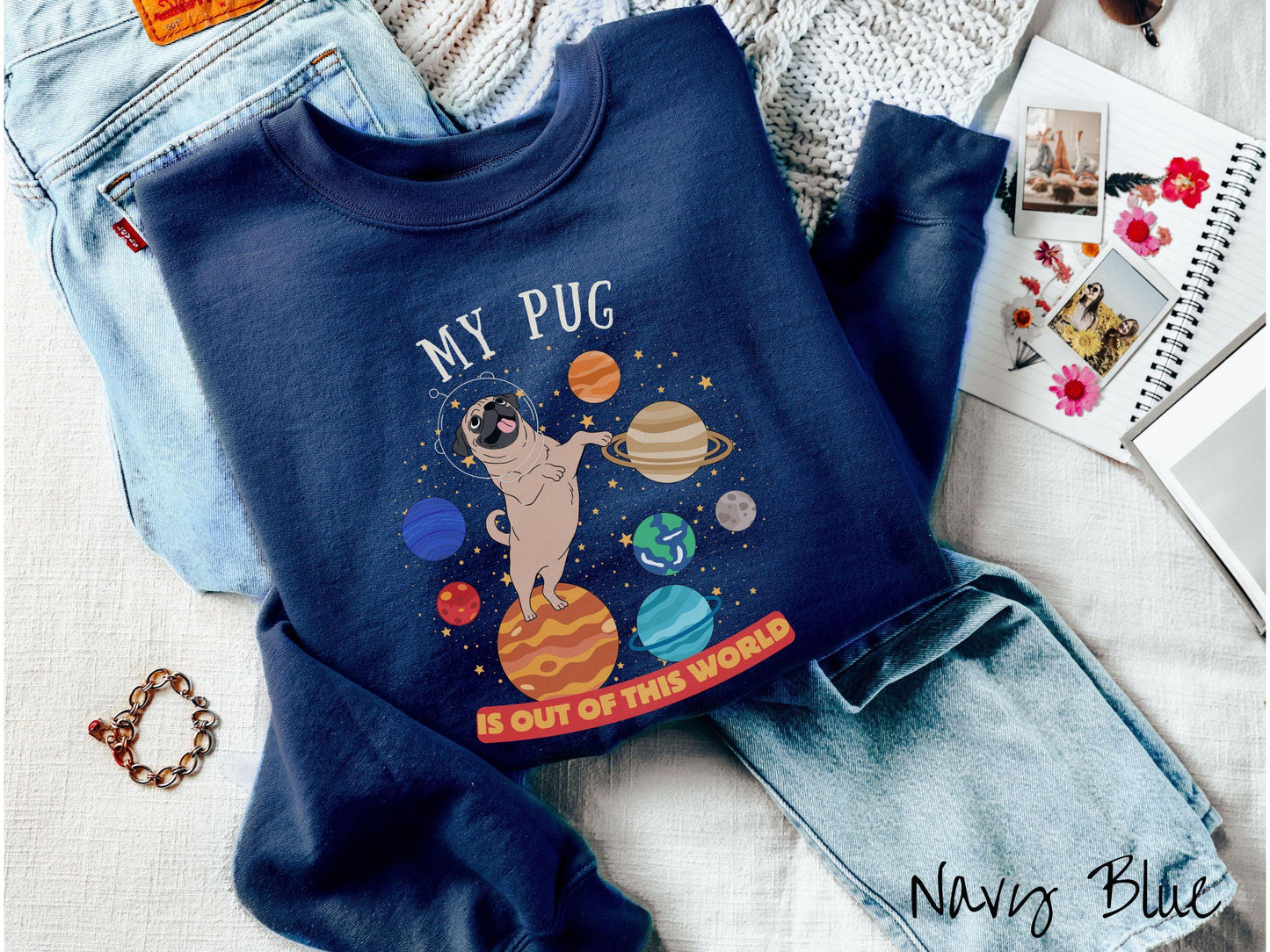 A vintage Gildan sweatshirt featuring the text My Pug is Out of This World. The design showcases an adorable Pug sitting proudly atop Jupiter, surrounded by a vibrant solar system filled with colorful planets and twinkling stars.