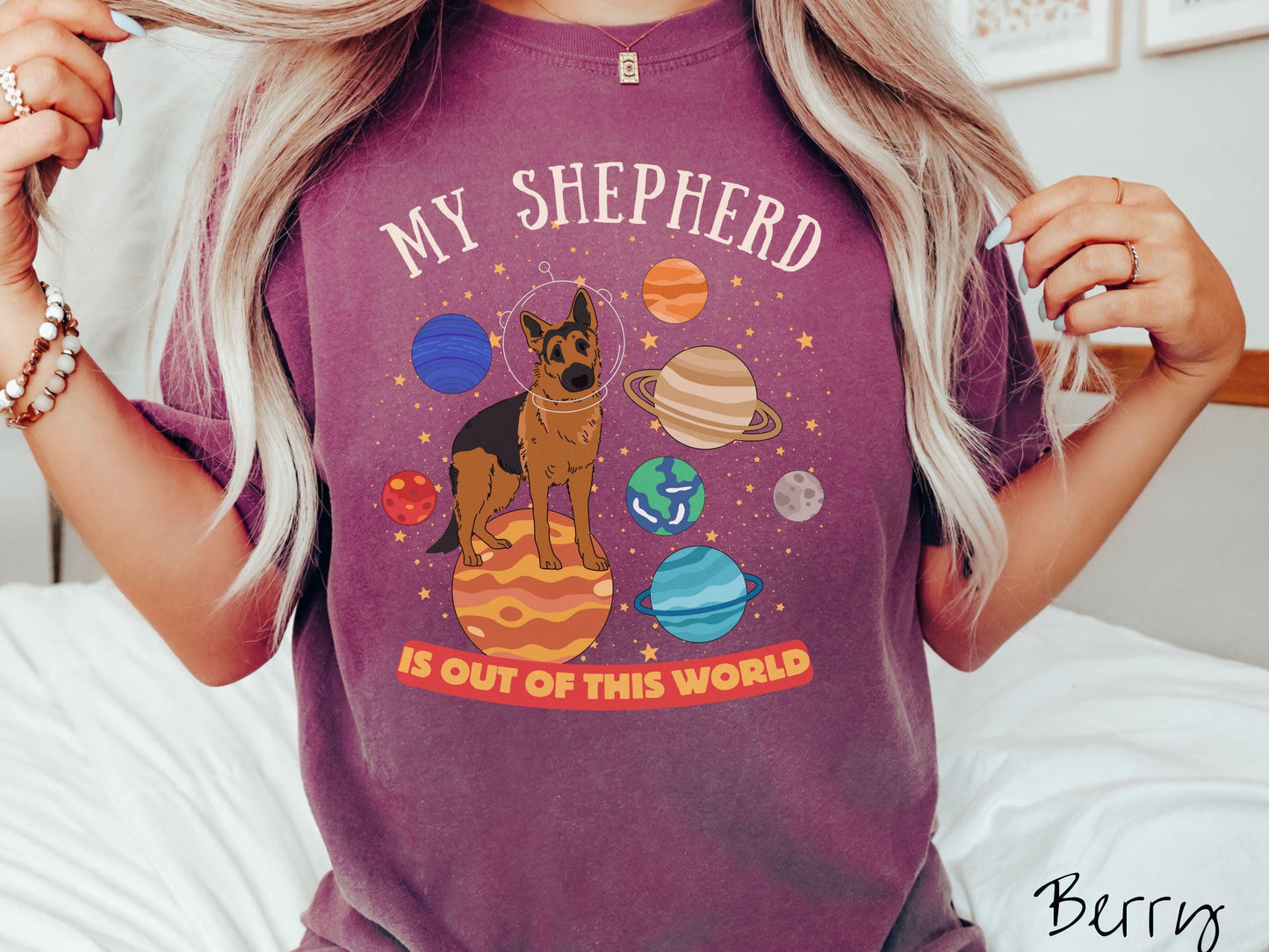 A vintage Comfort Colors t-shirt featuring the text My Shepherd is Out of This World. The design showcases a German Shepherd sitting proudly atop Jupiter, surrounded by a vibrant solar system filled with colorful planets and twinkling stars.