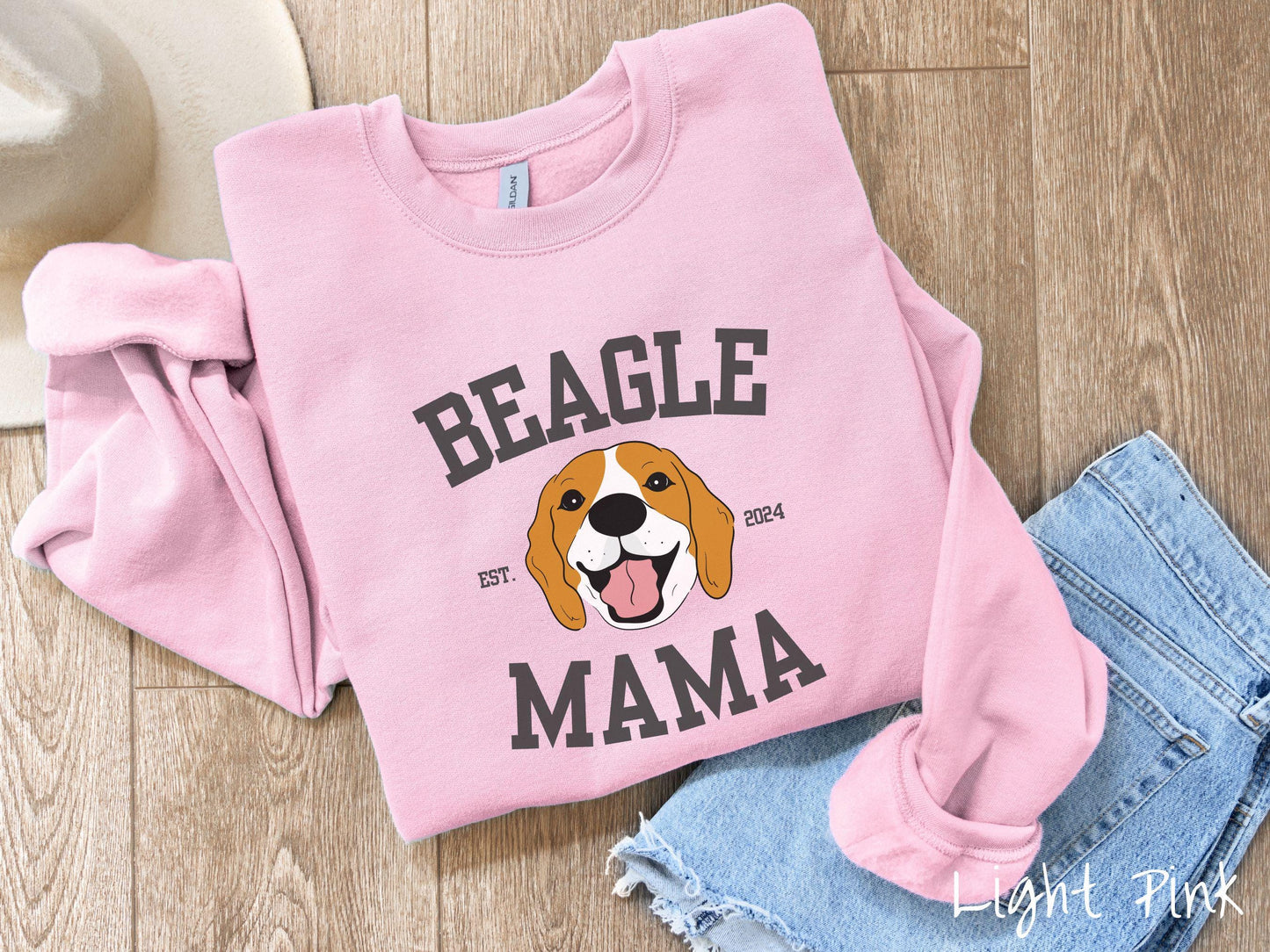 A vintage Gildan sweatshirt for every proud Beagle Mama! The design features the words Beagle Mama in a university-style font, framing an orange, black, and brown beagle. The playful touch of "EST. 2024" adds a personal charm to the design.