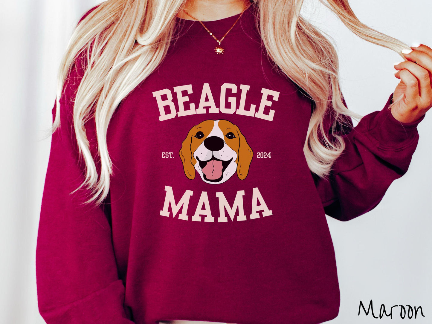 A vintage Gildan sweatshirt for every proud Beagle Mama! The design features the words Beagle Mama in a university-style font, framing an orange, black, and brown beagle. The playful touch of "EST. 2024" adds a personal charm to the design.