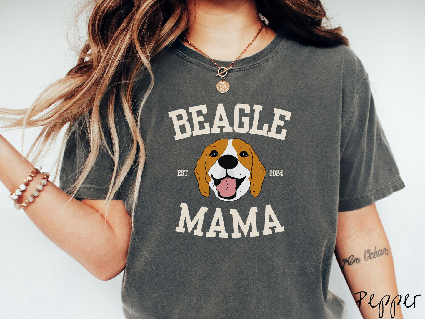 A vintage Comfort Colors t-shirt for every proud Beagle Mama! The design features the words Beagle Mama in a university-style font, framing an orange, black, and brown beagle. The playful touch of "EST. 2024" adds a personal charm to the design.