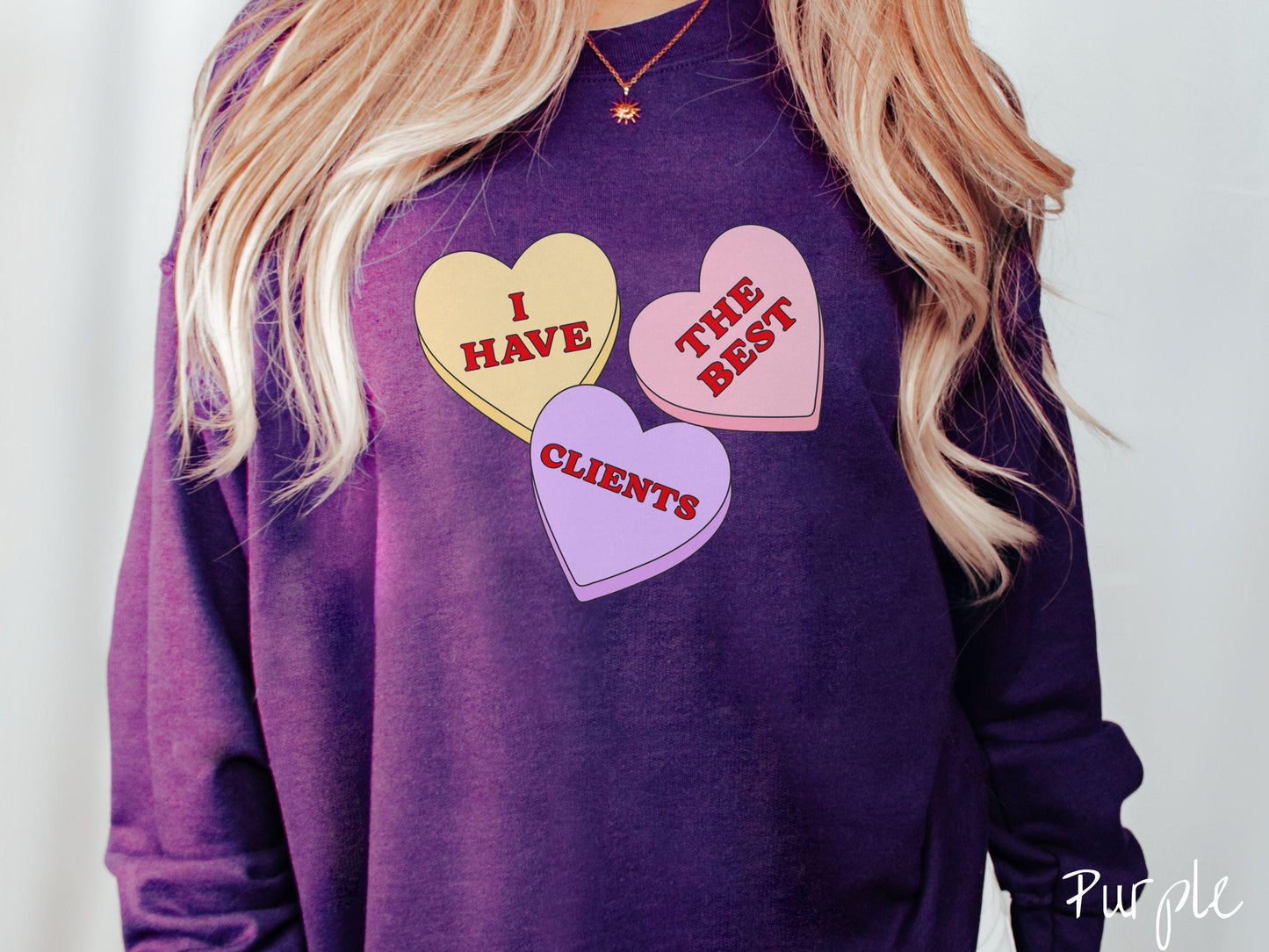 Show your appreciation for your amazing clients with this charming Gildan sweatshirt featuring three vibrant conversation hearts in yellow, red, and purple colors showcasing the text “I have the best clients” spread across the hearts.