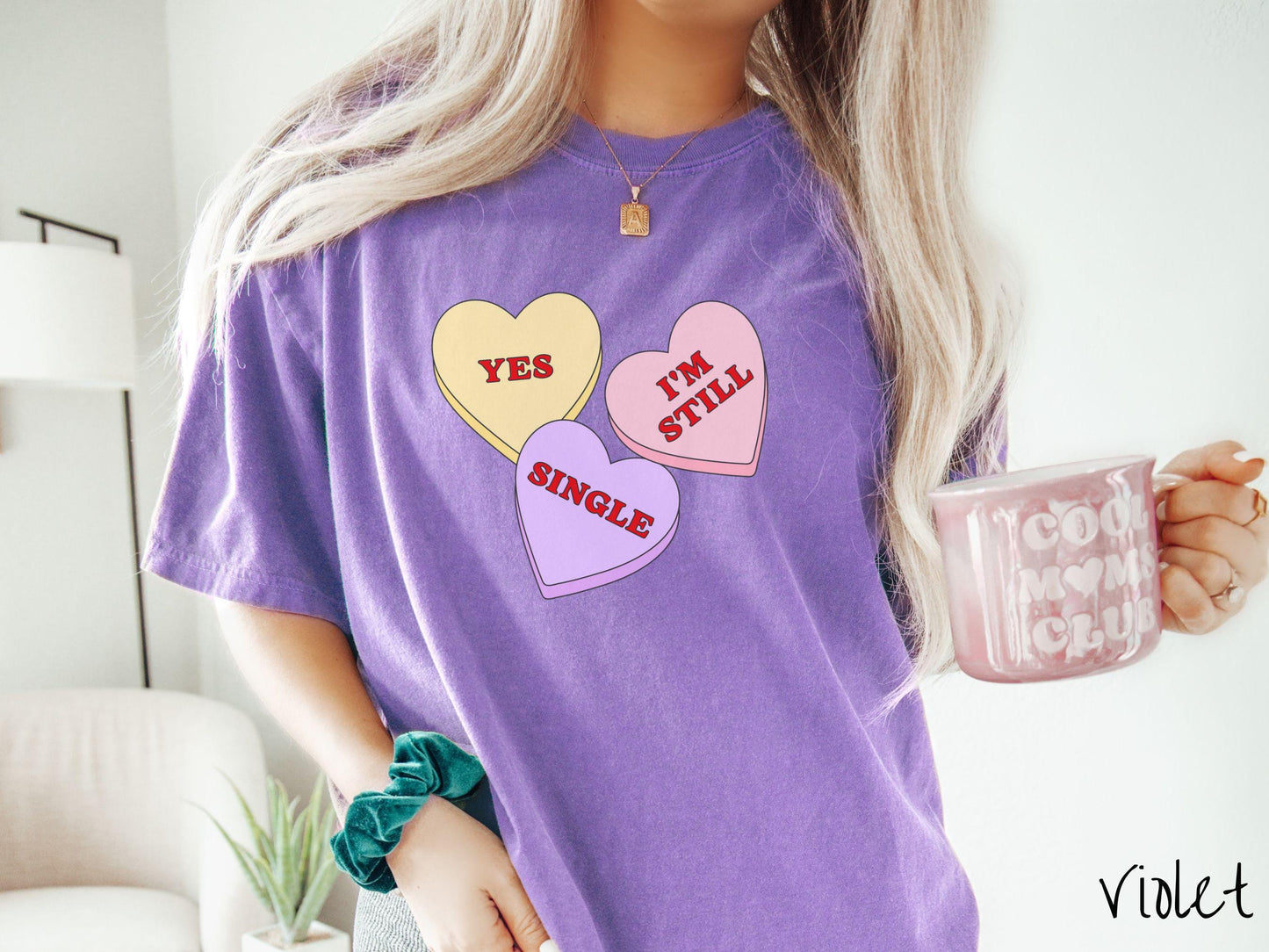 Make a bold statement this Valentine’s Day with this vintage Comfort Colors t-shirt featuring three vibrant conversation hearts in yellow, red, and purple, the design showcasing the cheeky phrase “Yes, I’m Still Single” spread across the hearts.