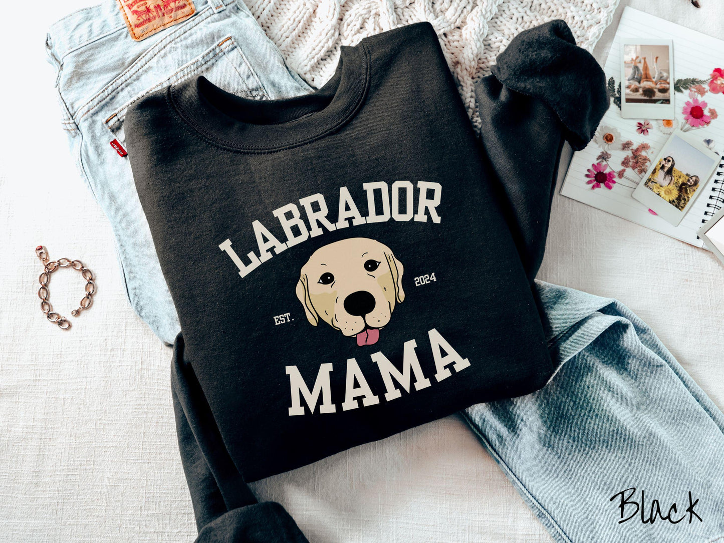 A vintage Gildan sweatshirt featuring bold block lettering that reads 'Labrador Mama.' At the center of the design, a playful yellow Labrador with its tongue out steals the spotlight, framed by the stylish text 'EST. 2024.'