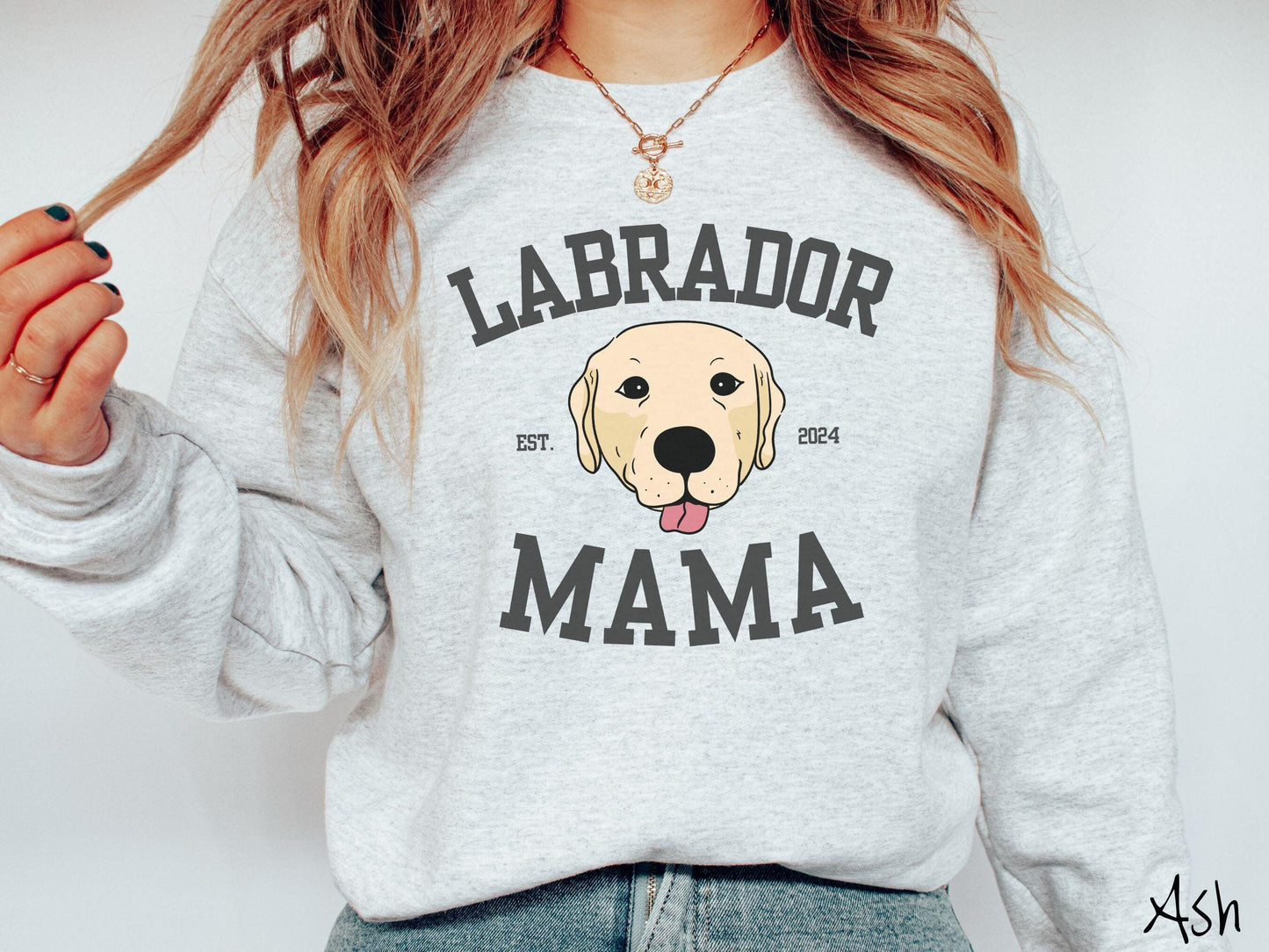 A vintage Gildan sweatshirt featuring bold block lettering that reads 'Labrador Mama.' At the center of the design, a playful yellow Labrador with its tongue out steals the spotlight, framed by the stylish text 'EST. 2024.'