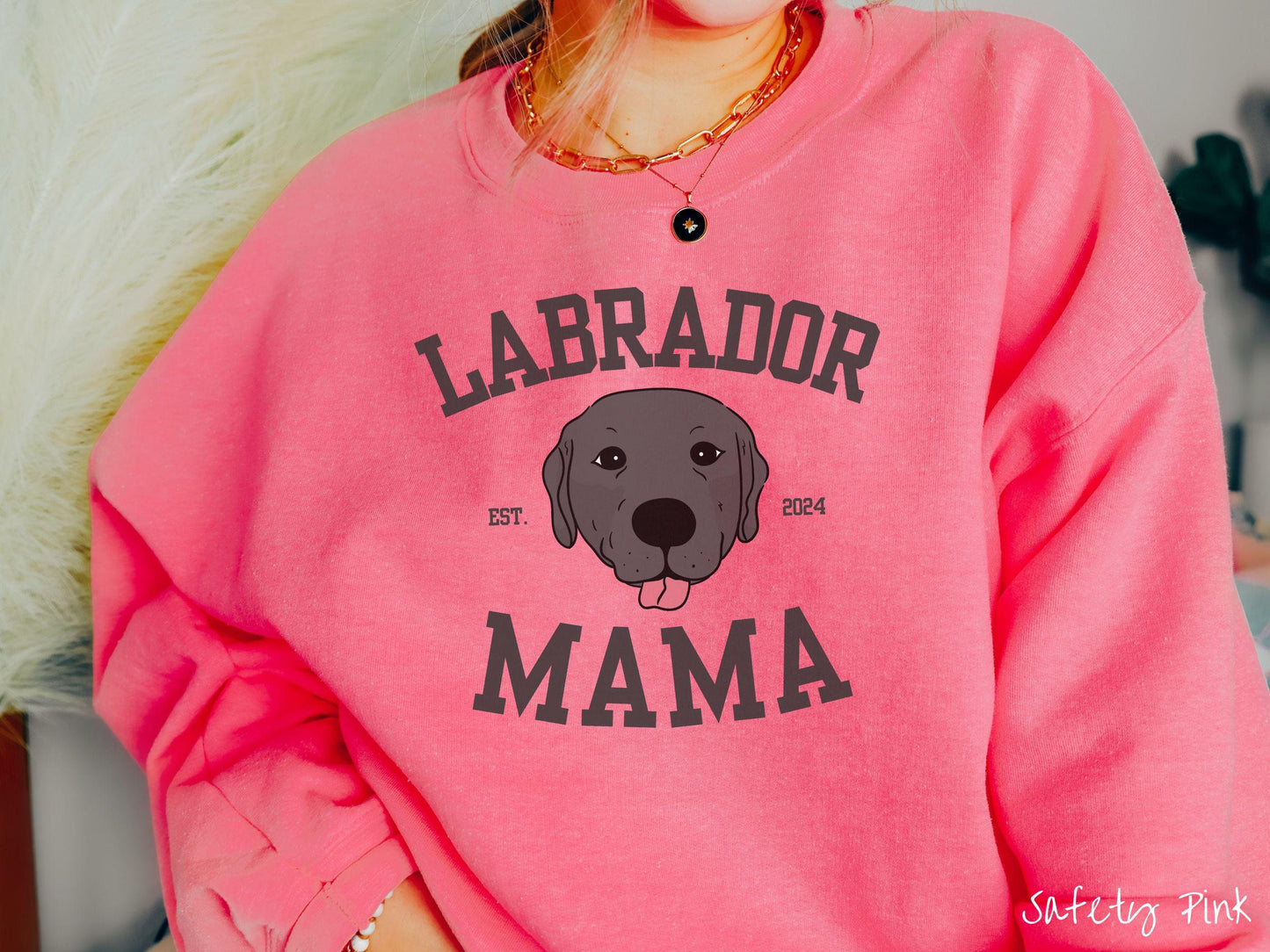 A vintage Gildan sweatshirt featuring bold block lettering that reads 'Labrador Mama.' At the center of the design, a playful black Labrador with its tongue out steals the spotlight, framed by the stylish text 'EST. 2024.'