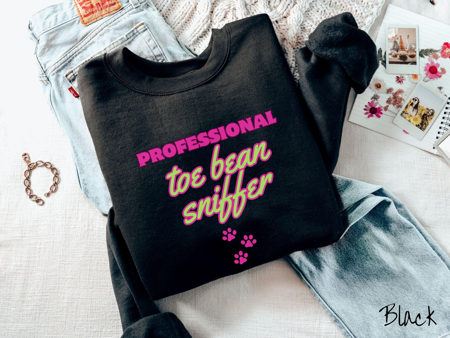 A vintage Gildan sweatshirt perfect for dog lovers who can’t resist those adorable toe beans! It features the funny text Professional Toe Bean Sniffer in bold pink and green fluorescent font, and below the text are three pink dog paw prints.