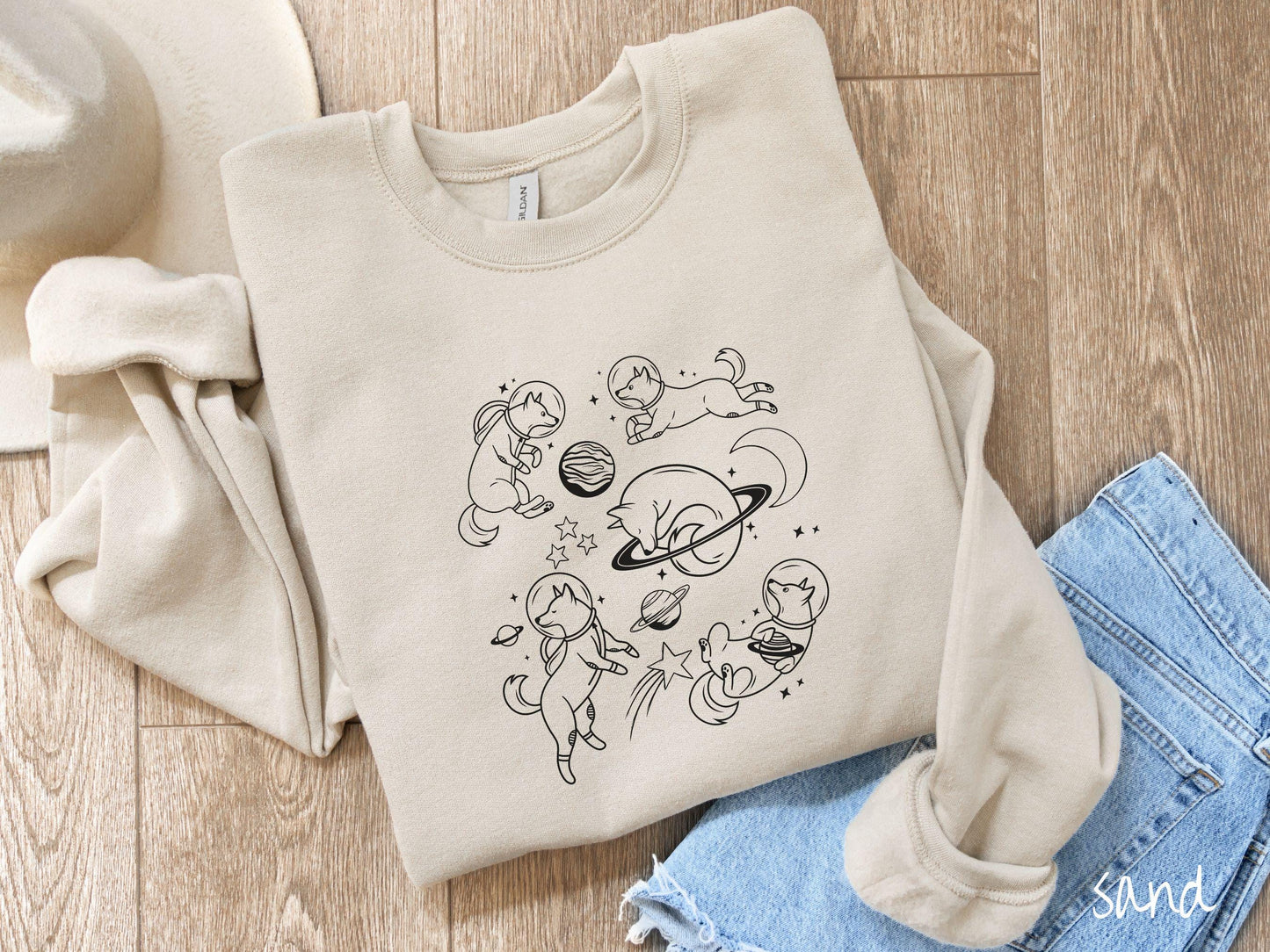 A vintage Gildan sweatshirt perfect for dog lovers and space enthusiasts alike, featuring outline designs of dogs in astronaut bubble helmets. This design showcases pups floating in the solar system, surrounded by stars, the moon, and planets.