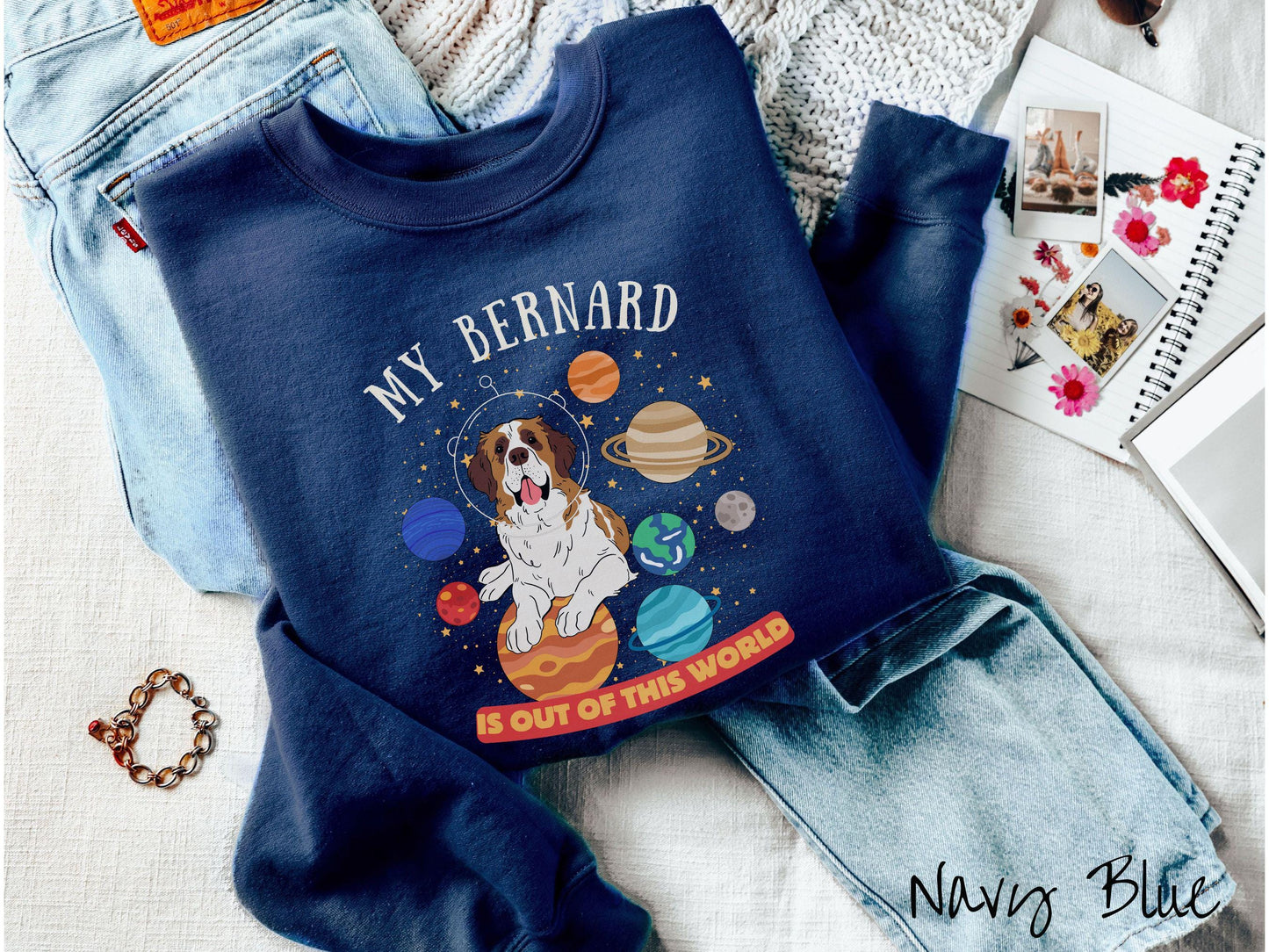 A vintage Gildan sweatshirt featuring the text 'My Bernard is Out of This World'. The design showcases an adorable St. Bernard sitting proudly atop Jupiter, surrounded by a vibrant solar system filled with colorful planets and twinkling stars.