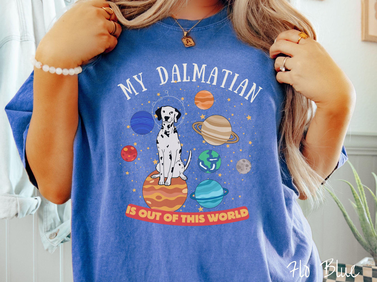 A vintage Comfort Colors t-shirt featuring the text My Dalmation is Out of This World. The design showcases a Dalmation sitting proudly atop Jupiter, surrounded by a vibrant solar system filled with colorful planets and twinkling stars.