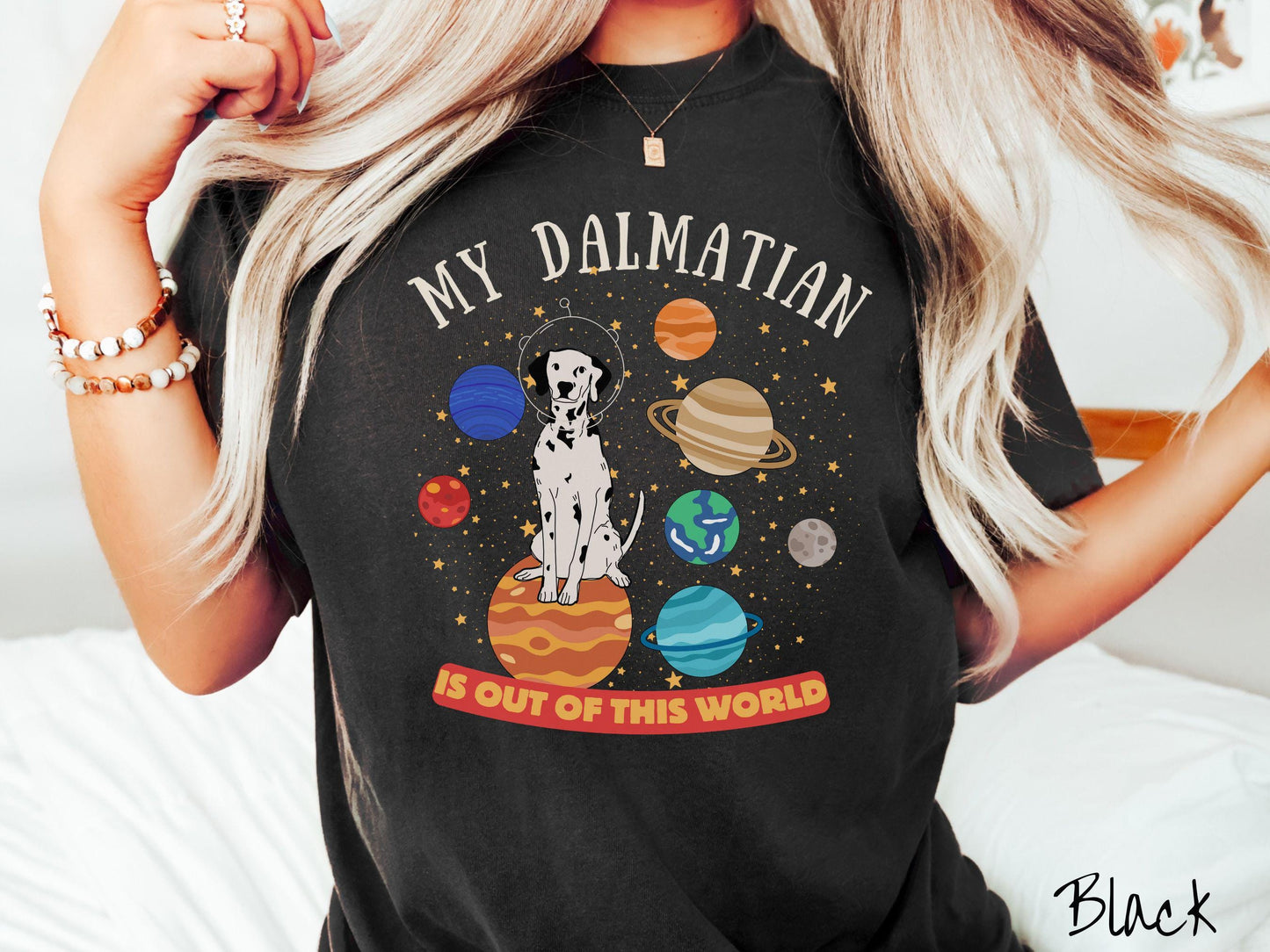 A vintage Comfort Colors t-shirt featuring the text My Dalmation is Out of This World. The design showcases a Dalmation sitting proudly atop Jupiter, surrounded by a vibrant solar system filled with colorful planets and twinkling stars.