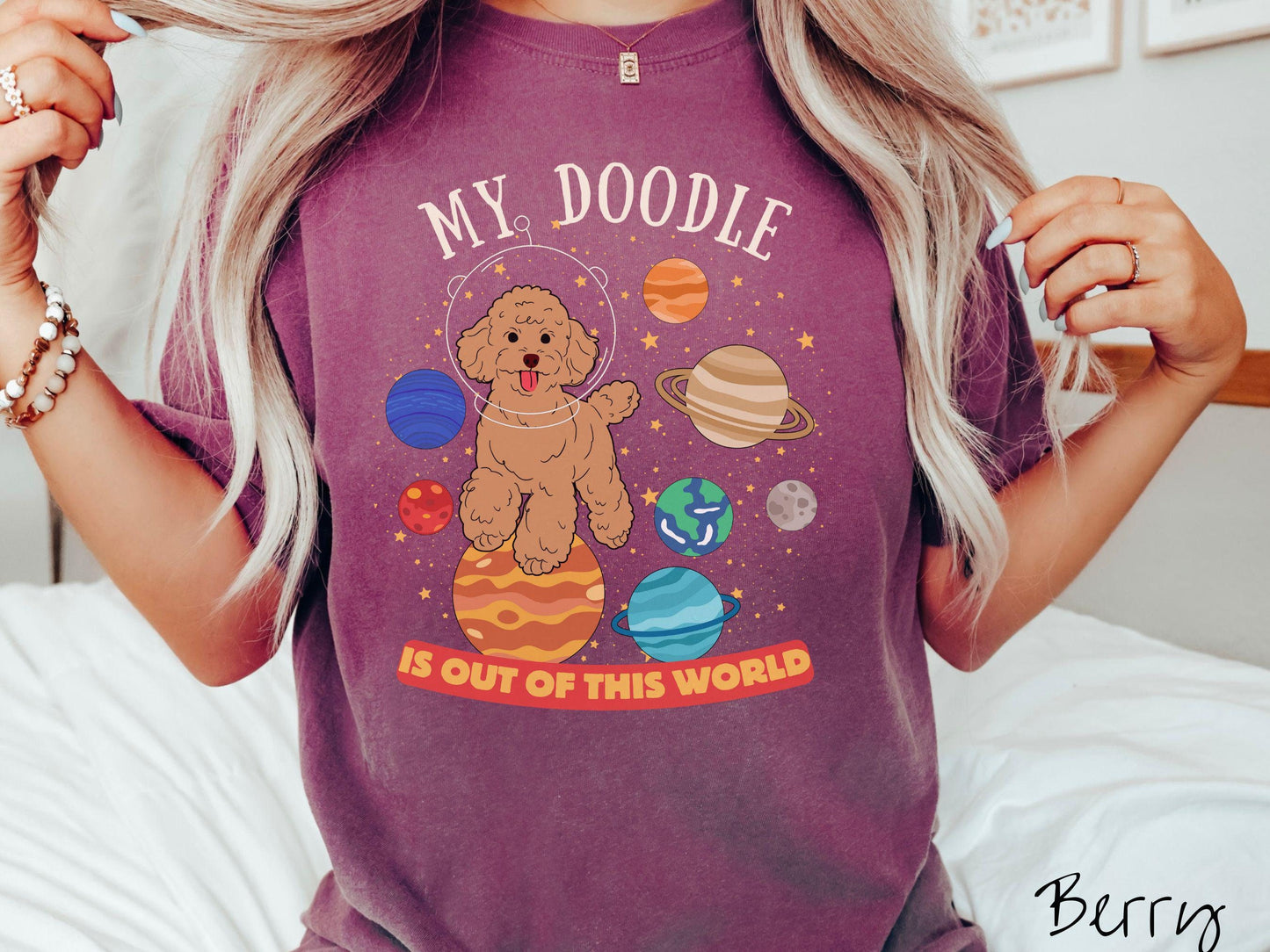 A vintage Comfort Colors t-shirt featuring the text My Doodle is Out of This World. The design showcases a Doodle sitting proudly atop Jupiter, surrounded by a vibrant solar system filled with colorful planets and twinkling stars.