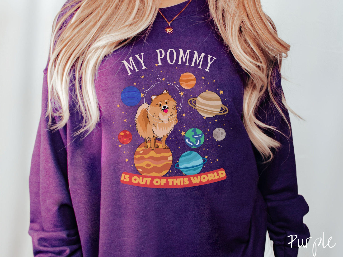 A vintage Gildan sweatshirt featuring the text My Pomeranian is Out of This World. The design showcases a German Shepherd sitting proudly atop Jupiter, surrounded by a vibrant solar system filled with colorful planets and twinkling stars.