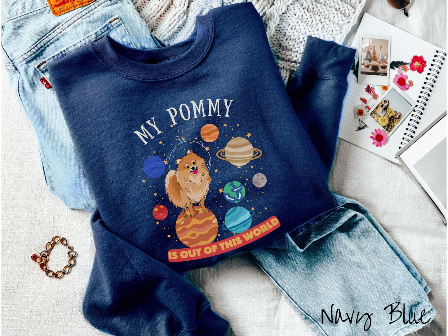 A vintage Gildan sweatshirt featuring the text My Pomeranian is Out of This World. The design showcases a German Shepherd sitting proudly atop Jupiter, surrounded by a vibrant solar system filled with colorful planets and twinkling stars.
