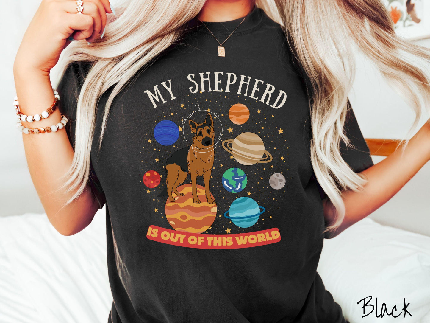 A vintage Comfort Colors t-shirt featuring the text My Shepherd is Out of This World. The design showcases a German Shepherd sitting proudly atop Jupiter, surrounded by a vibrant solar system filled with colorful planets and twinkling stars.