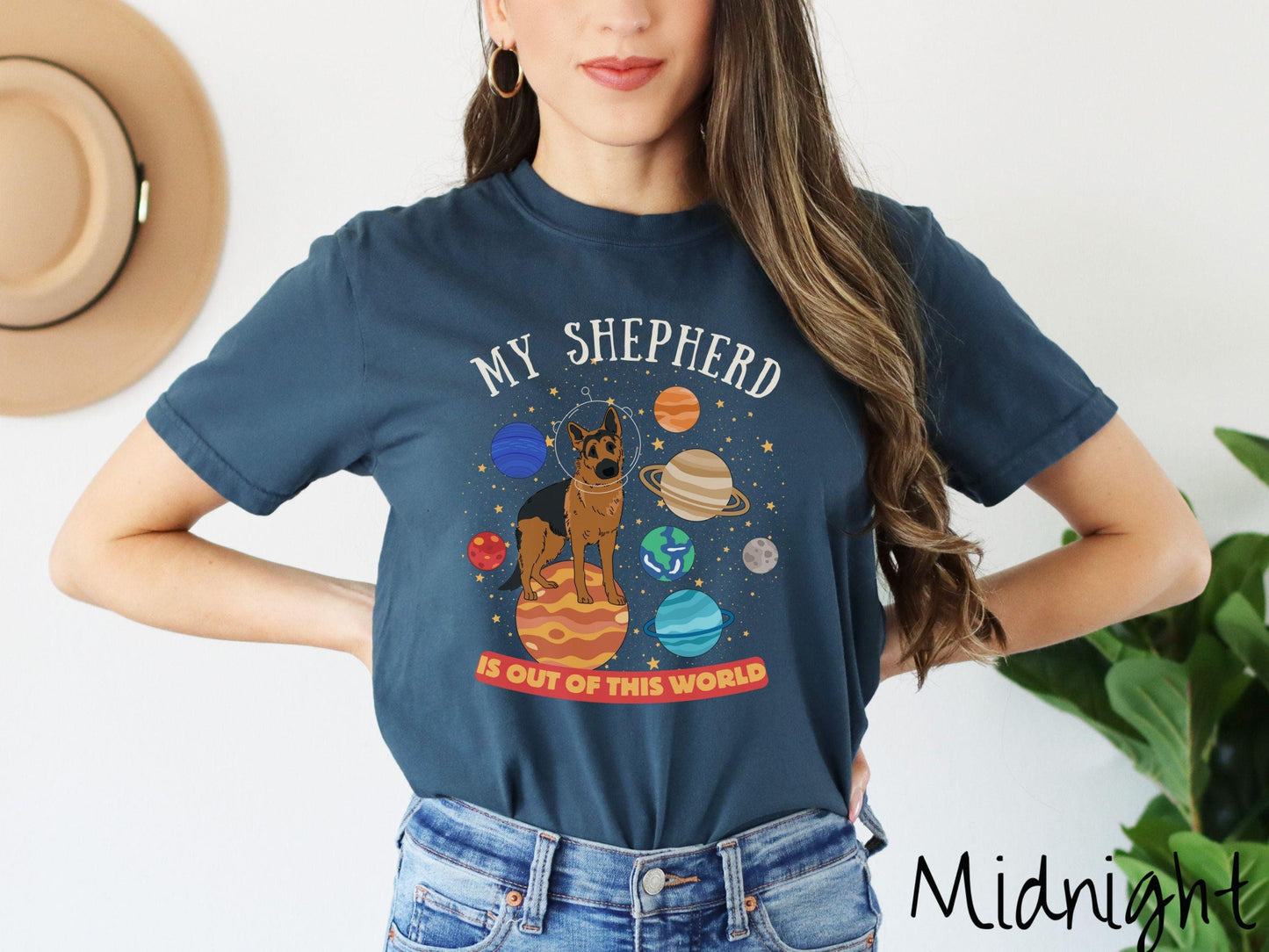 A vintage Comfort Colors t-shirt featuring the text My Shepherd is Out of This World. The design showcases a German Shepherd sitting proudly atop Jupiter, surrounded by a vibrant solar system filled with colorful planets and twinkling stars.