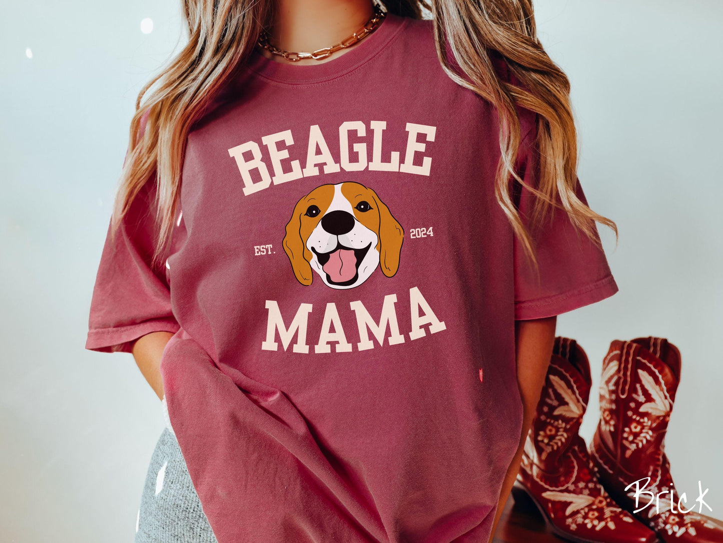 A vintage Comfort Colors t-shirt for every proud Beagle Mama! The design features the words Beagle Mama in a university-style font, framing an orange, black, and brown beagle. The playful touch of "EST. 2024" adds a personal charm to the design.