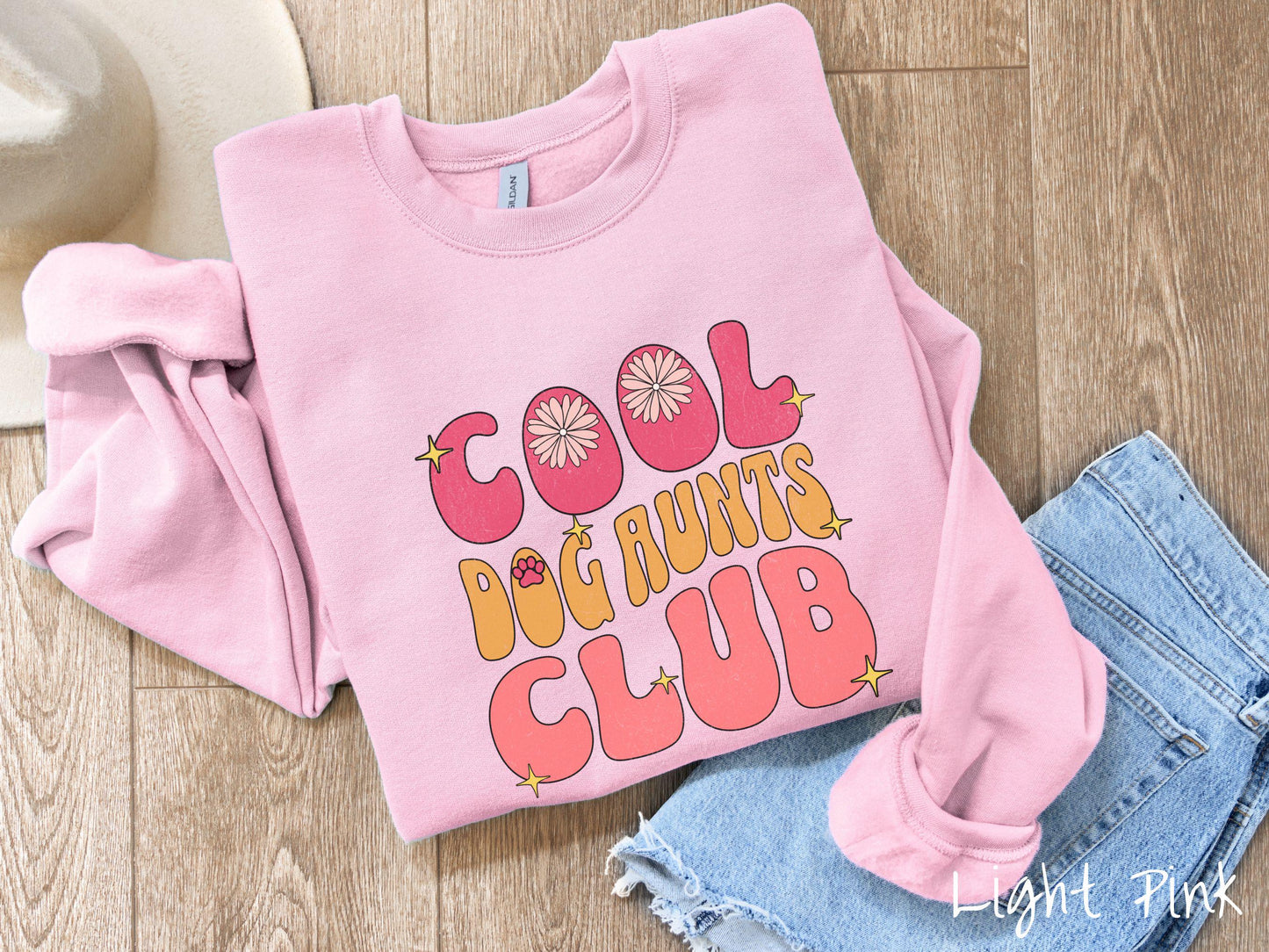 A vintage Gildan sweatshirt featuring the text "Cool Dog Aunts Club" in bold red, yellow, and orange fonts with flower petals nestled in the "O" of COOL, a cute red paw print in the "O" of DOG, and sparkling yellow stars throughout.