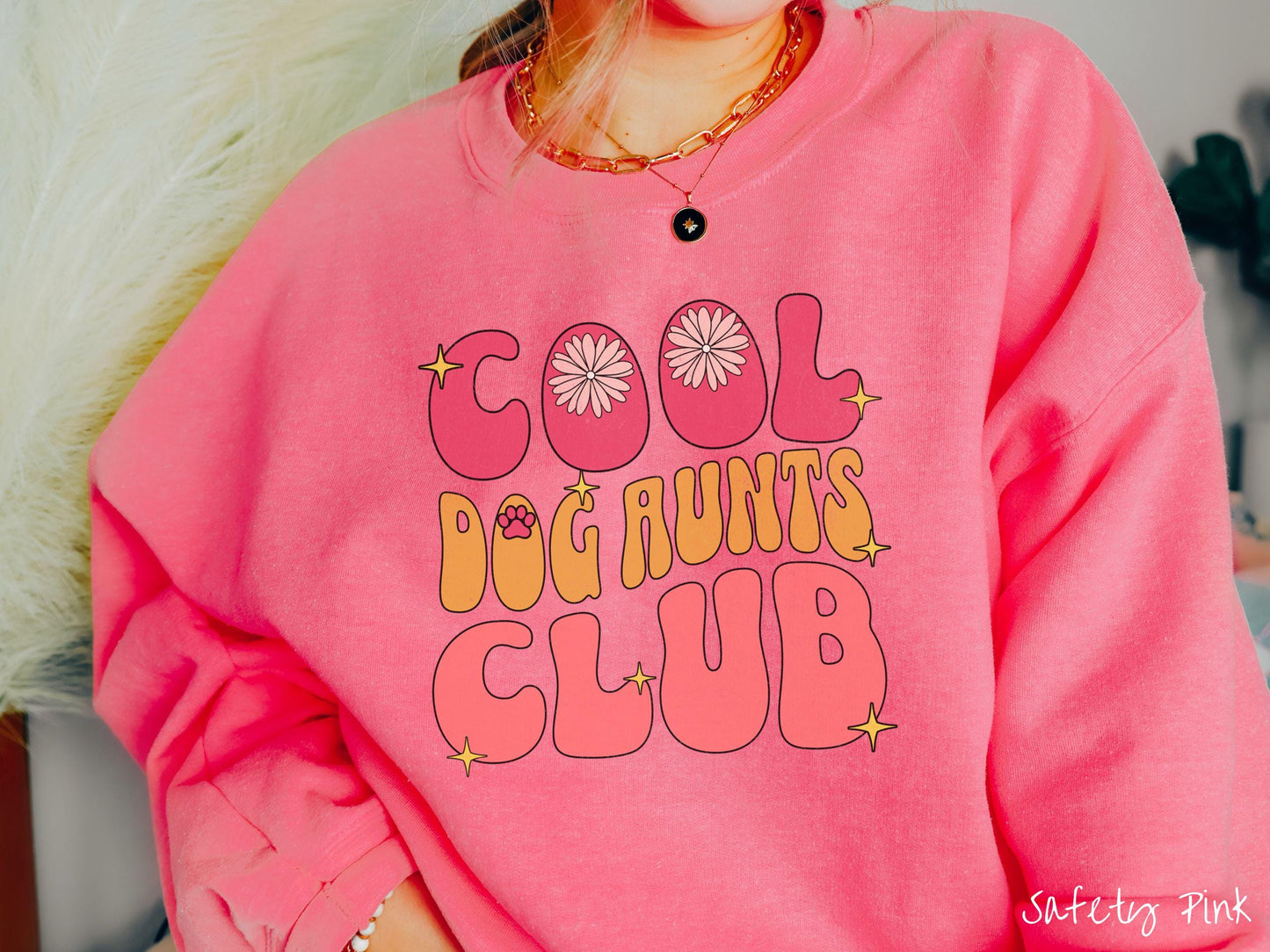 A vintage Gildan sweatshirt featuring the text "Cool Dog Aunts Club" in bold red, yellow, and orange fonts with flower petals nestled in the "O" of COOL, a cute red paw print in the "O" of DOG, and sparkling yellow stars throughout.