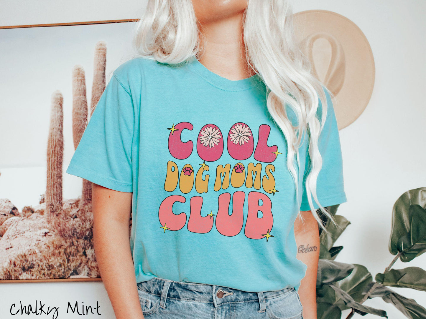 A vintage Comfort Colors t-shirt featuring the playful text Cool Dog Moms Club, this design is full of charming details. From flower petals nestled in the "O" of COOL to a cute red paw print in the "O" of DOG and sparkling yellow stars throughout.