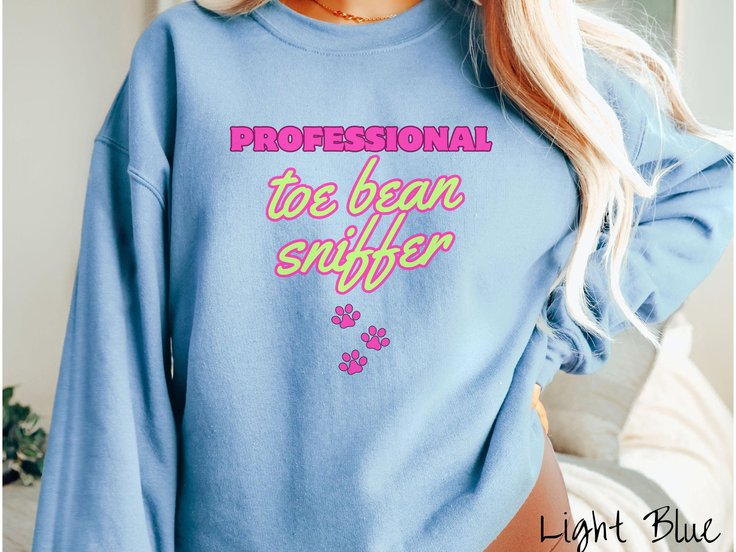 A vintage Gildan sweatshirt perfect for dog lovers who can’t resist those adorable toe beans! It features the funny text Professional Toe Bean Sniffer in bold pink and green fluorescent font, and below the text are three pink dog paw prints.