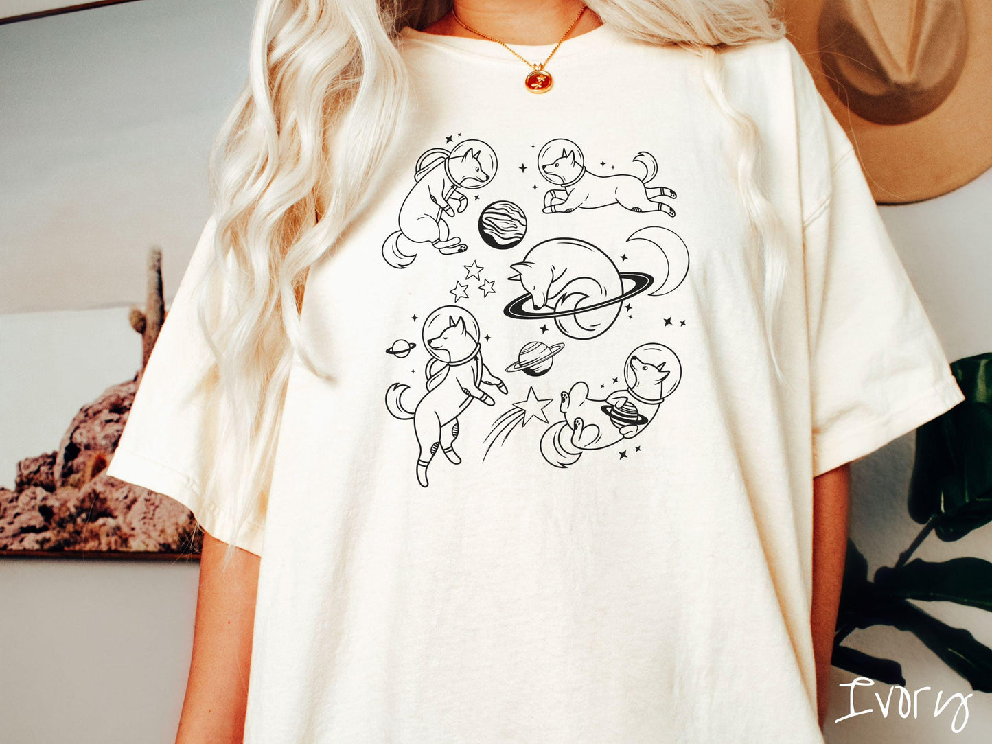 A vintage Comfort Colors t-shirt perfect for dog lovers and space enthusiasts alike, featuring outline designs of dogs in astronaut bubble helmets. This design showcases pups floating in the solar system, surrounded by stars, the moon, and planets.