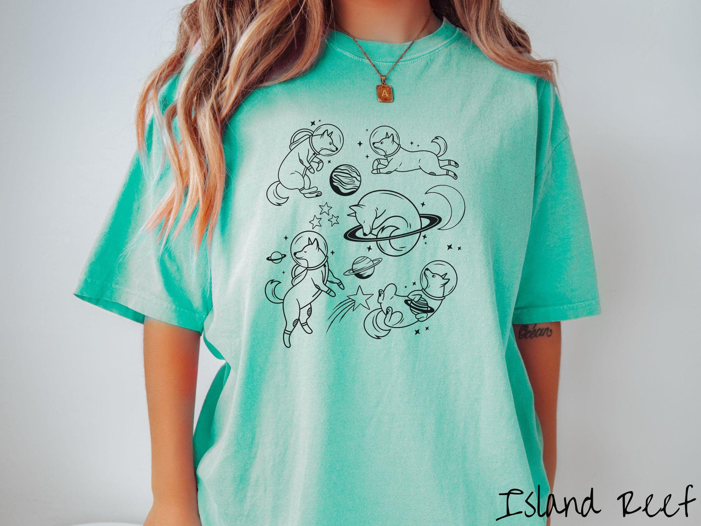 A vintage Comfort Colors t-shirt perfect for dog lovers and space enthusiasts alike, featuring outline designs of dogs in astronaut bubble helmets. This design showcases pups floating in the solar system, surrounded by stars, the moon, and planets.
