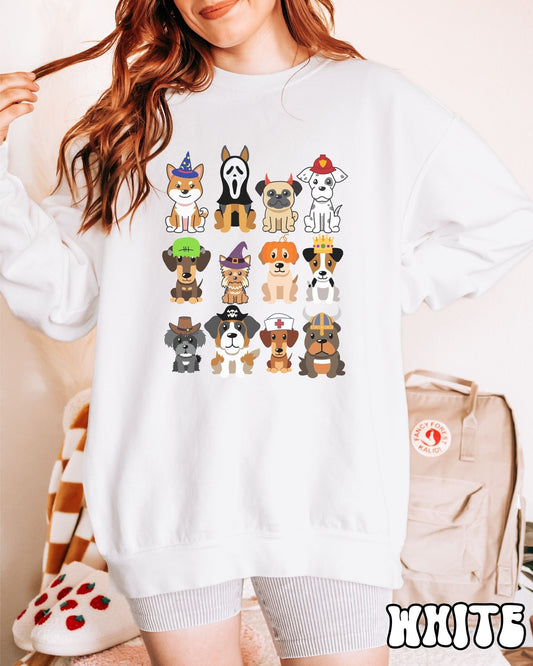 A woman wearing a cute, vintage white colored comfy Gildan sweatshirt with a four by three grid of different breeds of dogs dressed up in Halloween costumes. There is a dog dressed as a fireman and another as a nurse among others.