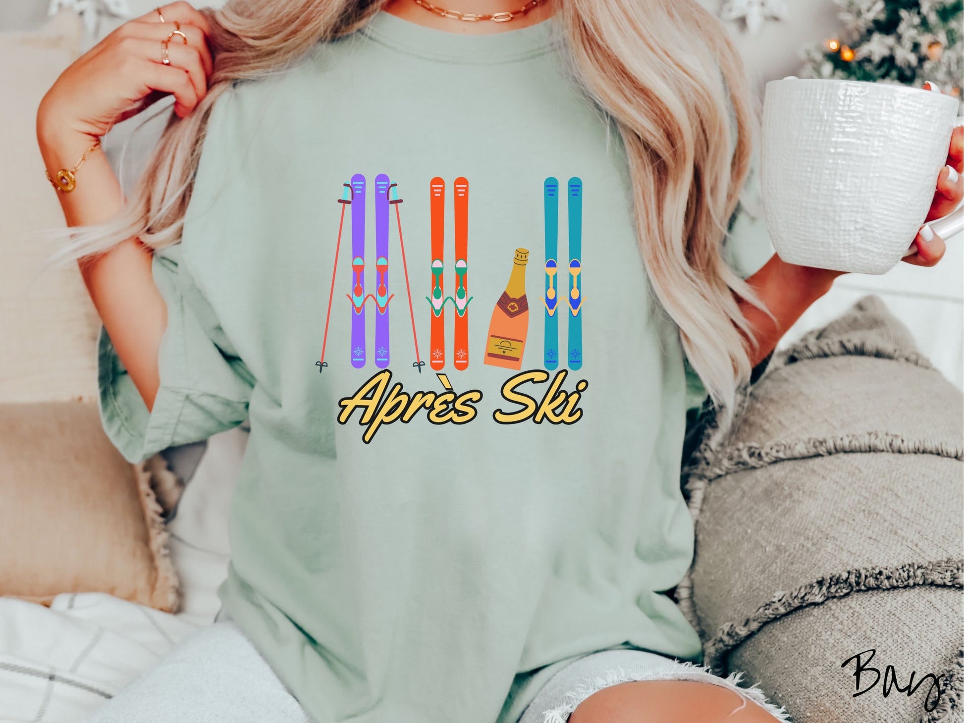 A woman wearing a vintage, bay colored shirt with sets of purple, orange, and turquoise snow skis standing upright, and a big bottle of champagne next to them. Below the skis is the text Apres Ski which is French for After Skiing.