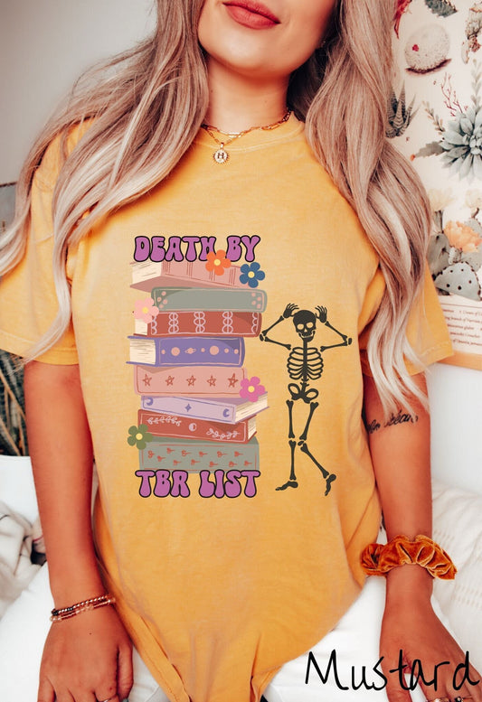 A woman wearing a cute citrus colored shirt with a huge stack of books with flowers sandwiched by the text Death by TBR List and a skeleton standing next to the stack with its hands on its head.