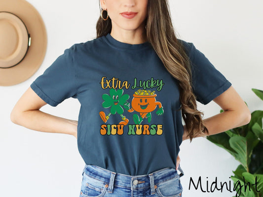 A woman wearing a vintage, midnight colored shirt with the text Extra Lucky SICU Nurse in yellow, orange, and green font. Between the text are a green clover and orange pot of gold smiling and walking together in step.