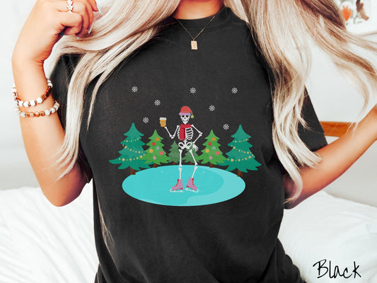 A woman wearing a vintage, black colored shirt with a female skeleton wearing a red Santa hat, red scarf, red and pink ice skates, and holding a coffee, ice skating on a pond at night with snowflakes in the air and Christmas trees in the background.