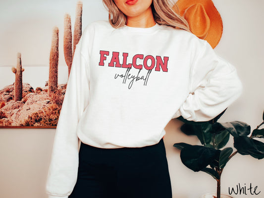 A woman wearing a cute, vintage white colored sweatshirt with the word Falcon in uppercase, red font across the front and the word volleyball below that in black, undercase cursive writing.