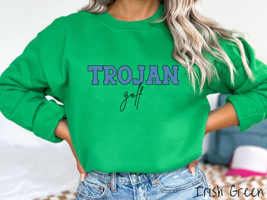 A woman wearing a cute, vintage Irish green colored sweatshirt with the word Trojan in uppercase, blue font across the front and the word golf below that in black, undercase cursive writing.