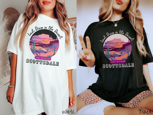 Two women wearing cute, vintage white and black colored Comfort Colors t-shirts with text Last Disco in the Desert and Kate’s Bachelorette Scottsdale, with a picture of the Arizona desert in pink, orange, purple, and green colors.