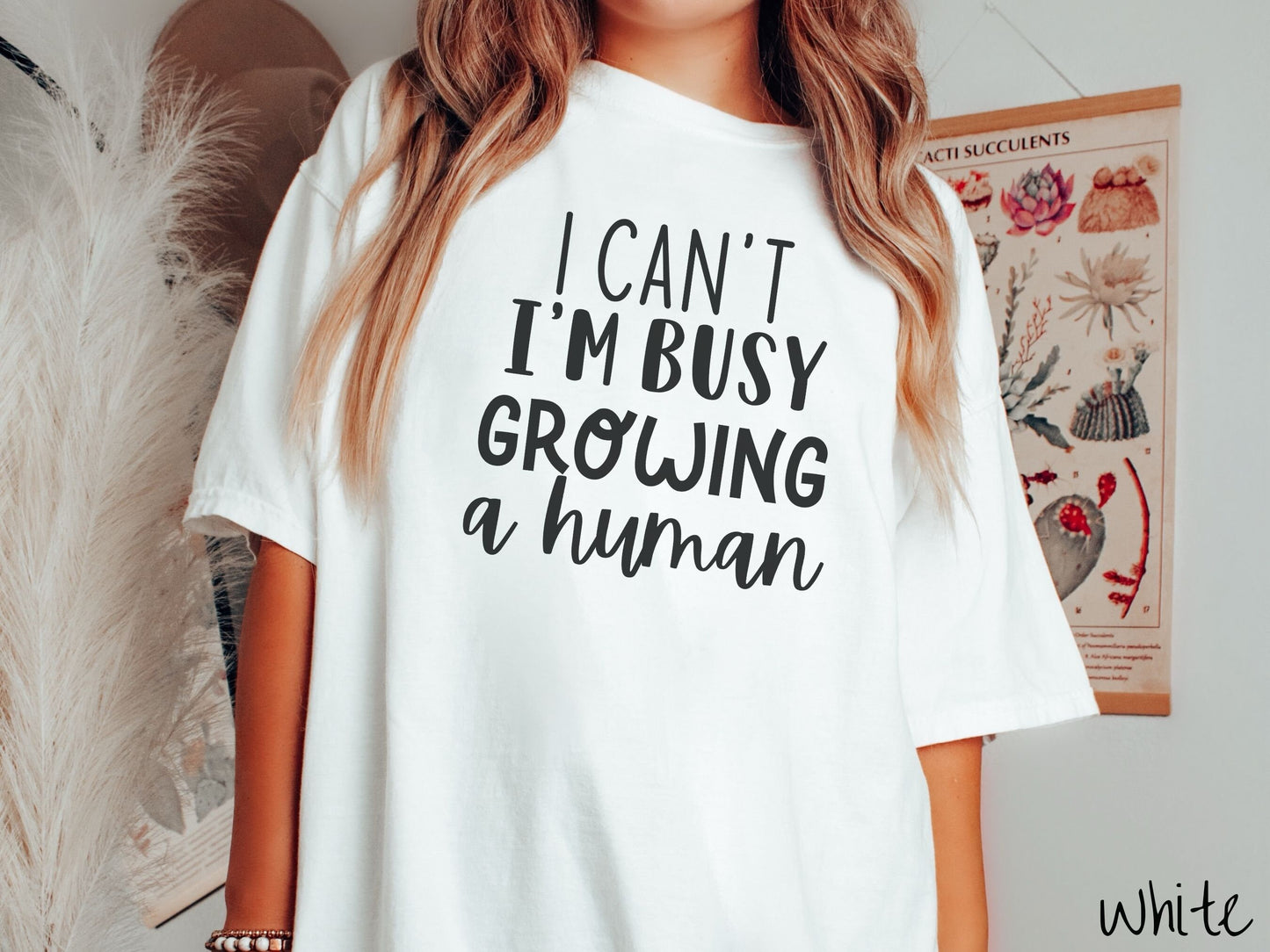 A woman wearing a vintage, white colored Comfort Colors t-shirt with the text in white font I Can’t I’m Busy Growing A Human.