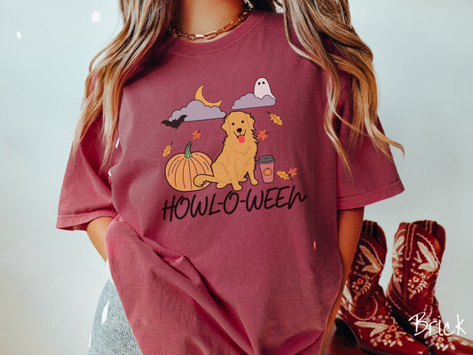 A woman wearing a vintage, brick colored Comfort Colors t-shirt with the text Howl-O-Ween across the front. Above are a smiling golden retriever dog, an orange pumpkin, a pumpkin-spiced latte, fall leaves, and a ghost and bat in the air.