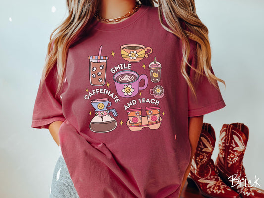 A woman wearing a cute, vintage brick colored Comfort Colors T-shirt with text Smile Caffeinate and Teach. There is an iced coffee, two cups of hot coffee, a blended coffee drink with whipped cream, to-go coffees, and a pot of coffee.