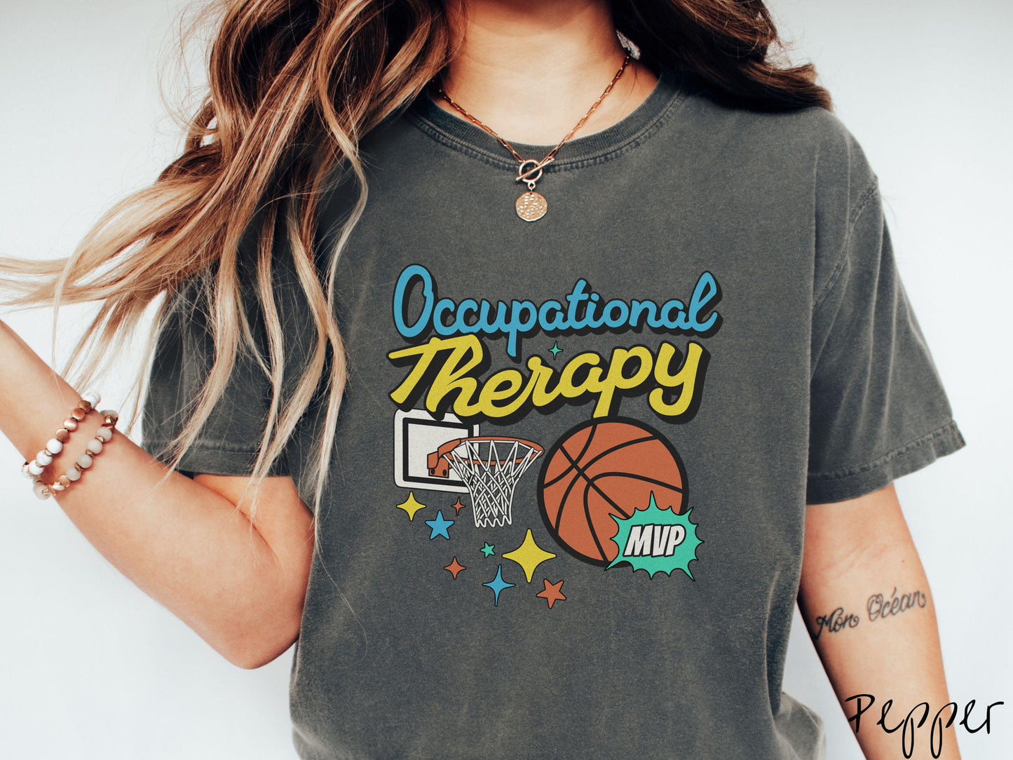 A vintage, pepper colored Comfort Colors T-Shirt features the phrase "Occupational Therapy" above a basketball goal, complemented by a bold basketball graphic with the text "MVP".
