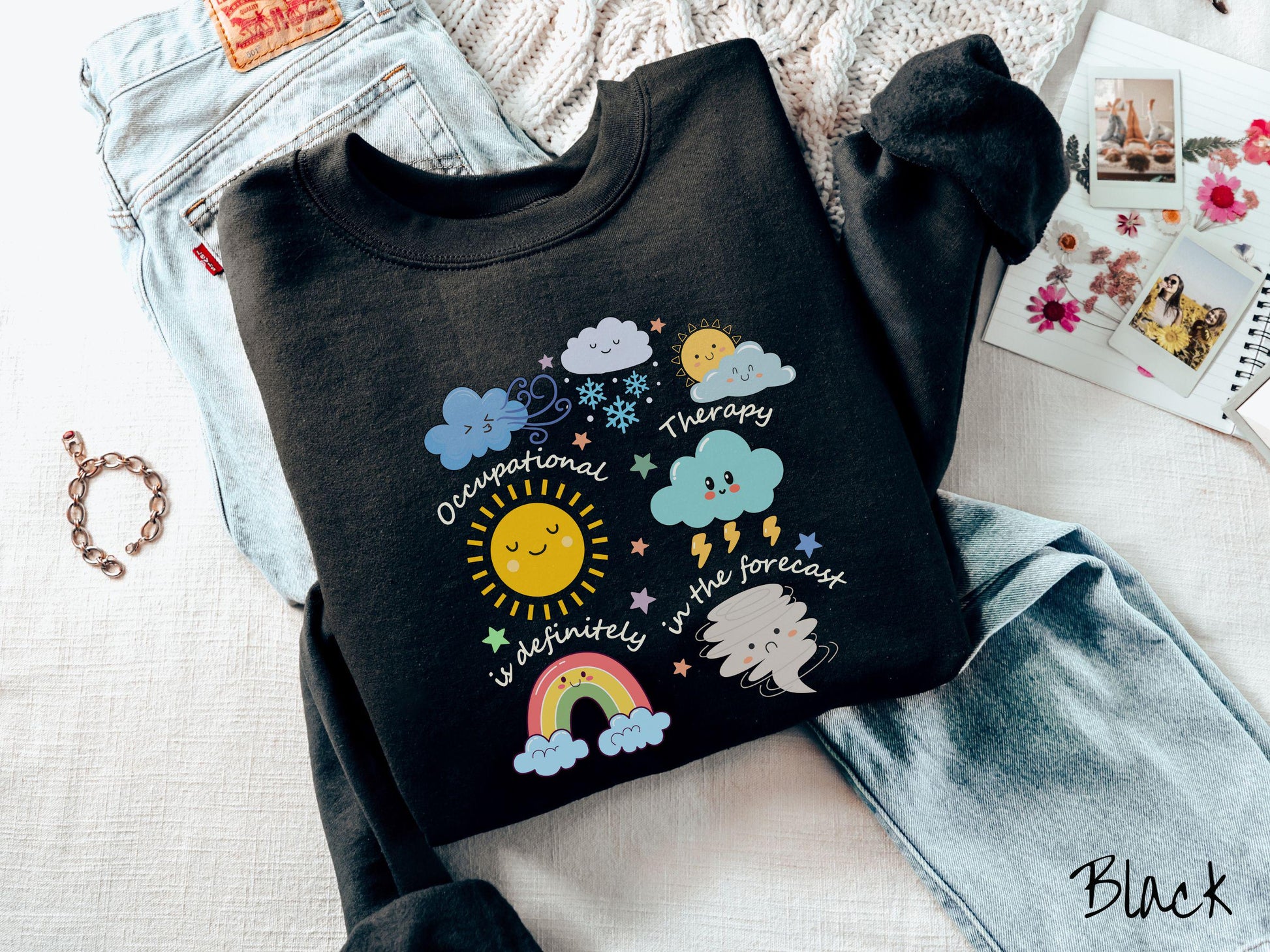 A vintage, black colored Gildan sweatshirt featuring the text Occupational Therapy is definitely in the forecast and surrounded by weather elements like clouds, rain clouds, a shining sun, lightning, a rainbow, and a tornado.